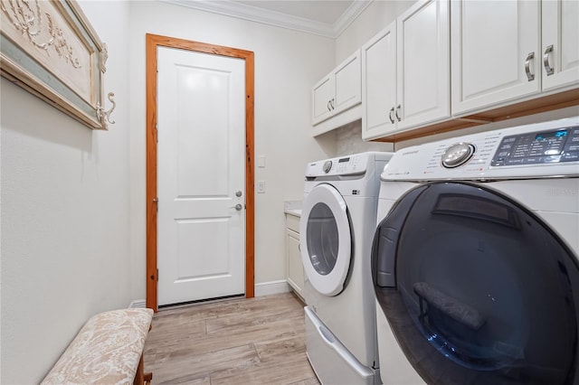 clothes washing area featuring cabinets, light wood-type flooring, separate washer and dryer, and crown molding