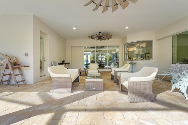 living room featuring ceiling fan with notable chandelier