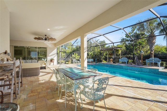 view of swimming pool featuring pool water feature, glass enclosure, ceiling fan, and a patio area