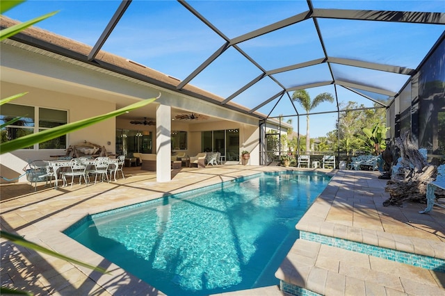 view of swimming pool featuring ceiling fan, a patio area, an outdoor living space, and glass enclosure