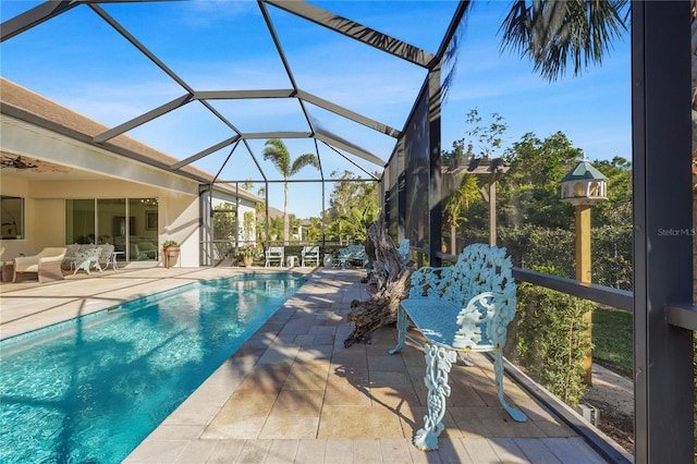 view of pool with glass enclosure and a patio