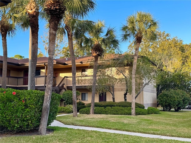 view of front of property featuring a balcony and a front yard