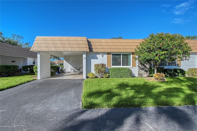 view of front of home with a front yard and a carport