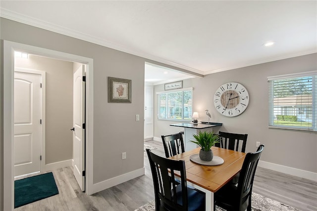 dining space featuring a wealth of natural light, light hardwood / wood-style flooring, and crown molding