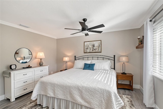 bedroom featuring hardwood / wood-style floors, ceiling fan, and ornamental molding