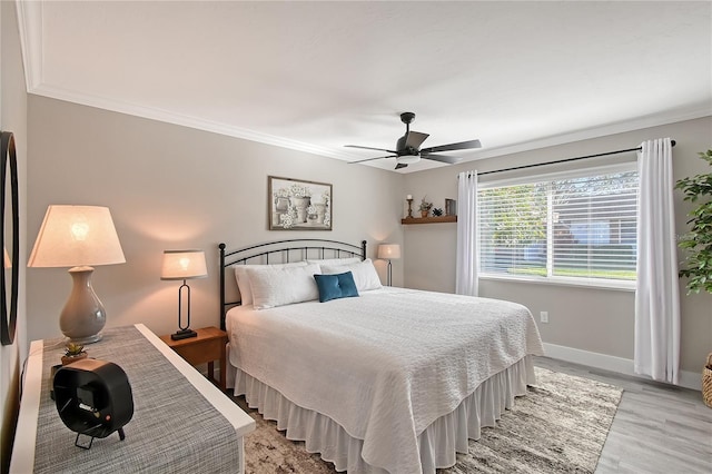 bedroom with light wood-type flooring, ceiling fan, and ornamental molding