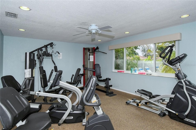 exercise area with a textured ceiling and ceiling fan