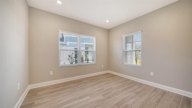 empty room with light wood-type flooring and a wealth of natural light