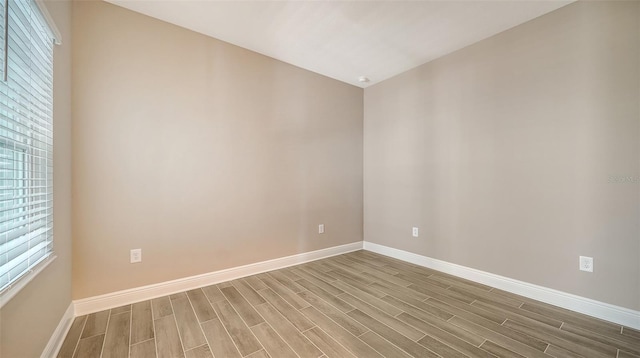 spare room with wood-type flooring and a wealth of natural light