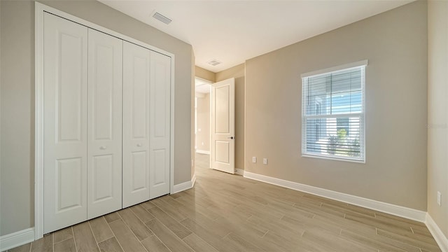 unfurnished bedroom with light hardwood / wood-style floors and a closet