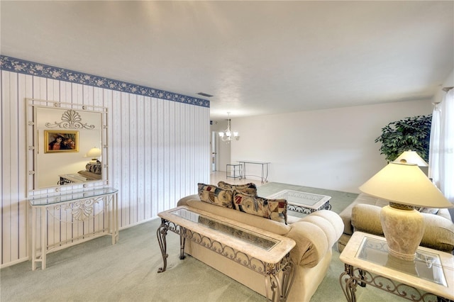 carpeted living room featuring an inviting chandelier