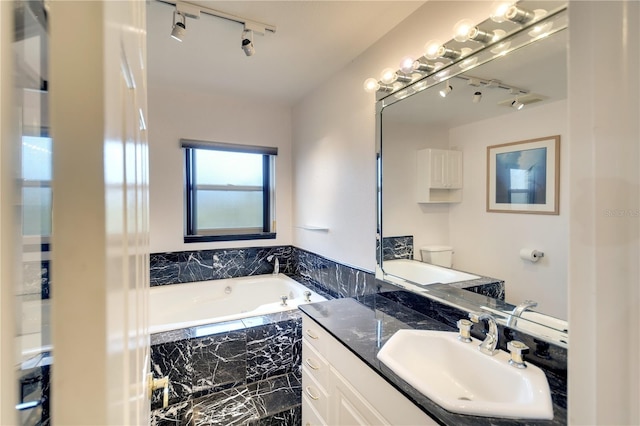 bathroom featuring a relaxing tiled tub, toilet, and vanity