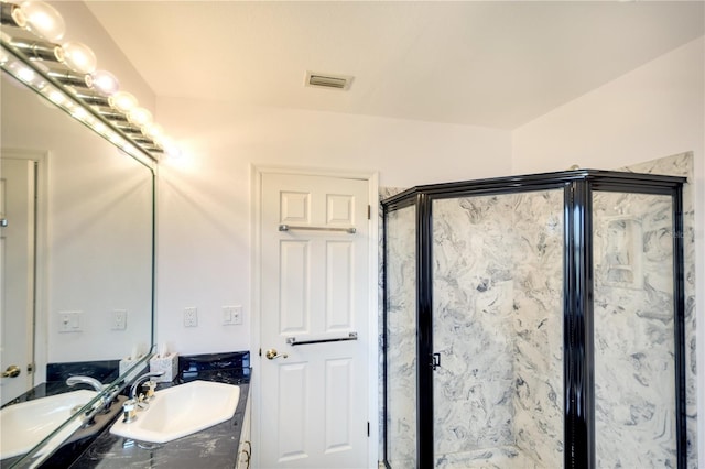 bathroom featuring vanity and a shower with shower door