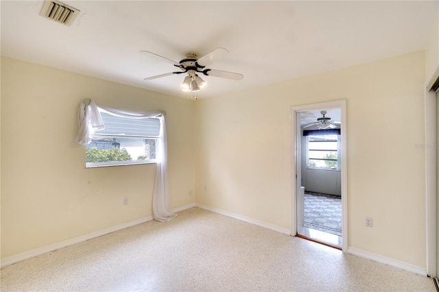 unfurnished room with ceiling fan and a healthy amount of sunlight