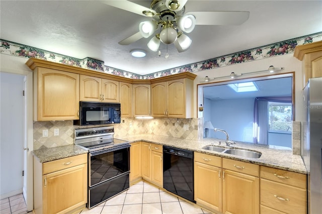 kitchen featuring a skylight, sink, decorative backsplash, light tile patterned flooring, and black appliances