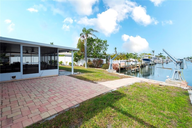 view of dock featuring a water view, a yard, and a patio