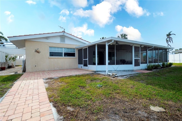 rear view of property featuring a sunroom and a yard