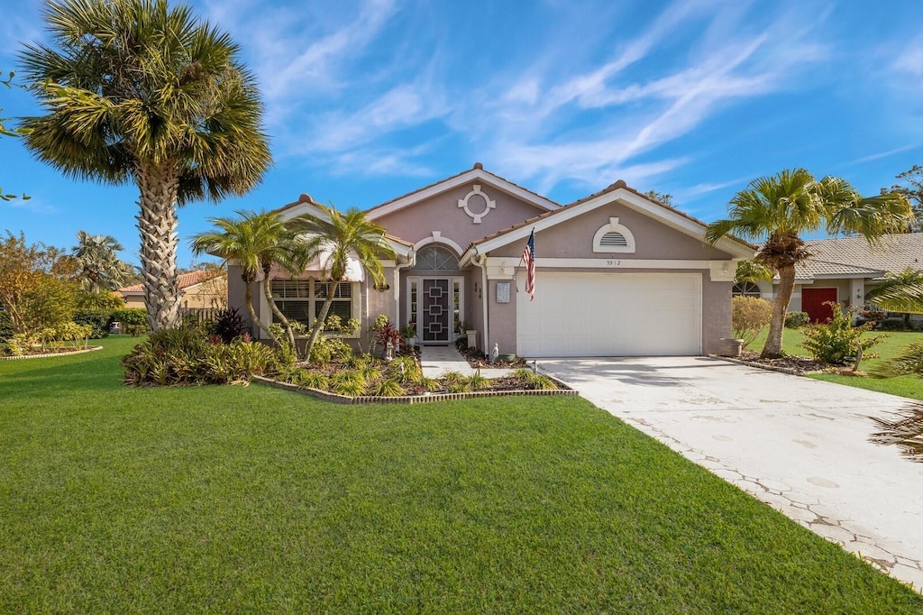 view of front of property featuring a front yard and a garage