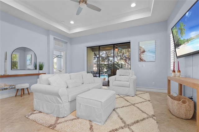 living room featuring ceiling fan and a tray ceiling