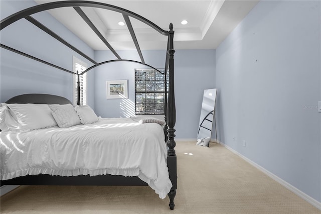 bedroom featuring a raised ceiling, light colored carpet, and ornamental molding