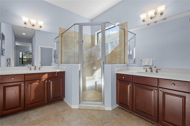 bathroom with tile patterned flooring, vanity, vaulted ceiling, and walk in shower