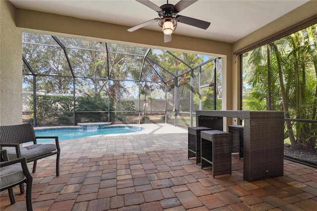 view of patio / terrace featuring pool water feature, ceiling fan, a fenced in pool, and glass enclosure