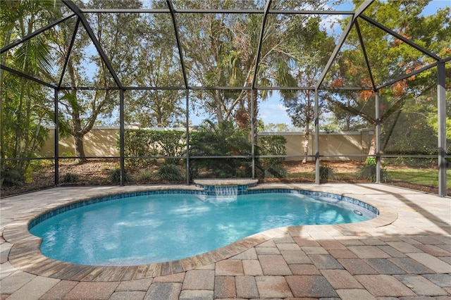 view of pool with glass enclosure and a patio area