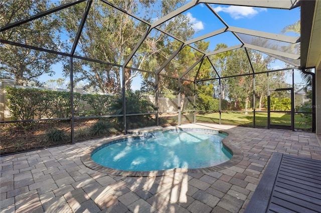 view of pool with glass enclosure and a patio area