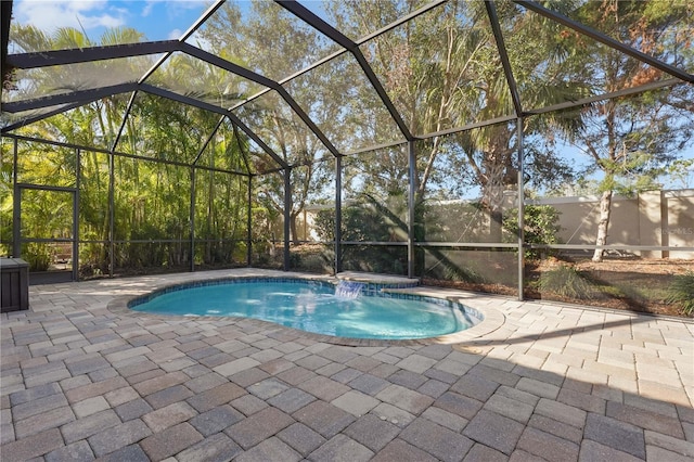 view of swimming pool with a hot tub, glass enclosure, and a patio area