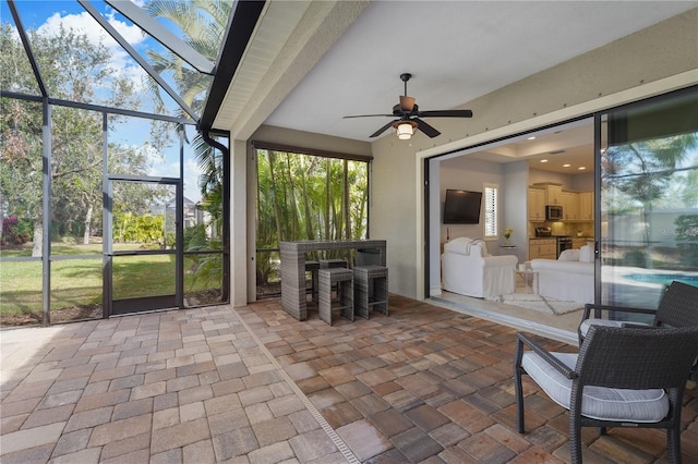 unfurnished sunroom featuring ceiling fan