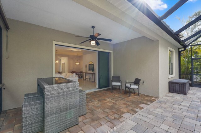 view of patio featuring a lanai and a ceiling fan