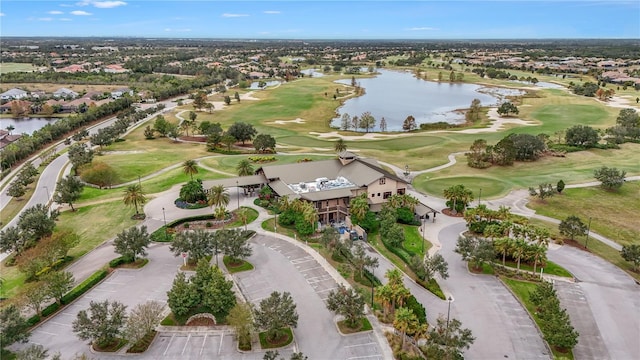 drone / aerial view with view of golf course and a water view