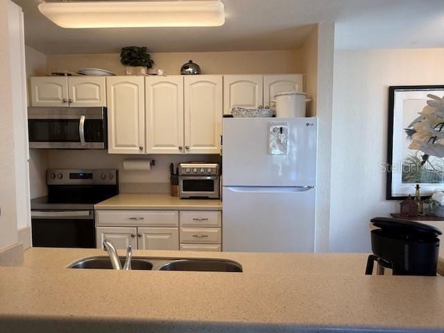 kitchen with white cabinetry, sink, and appliances with stainless steel finishes