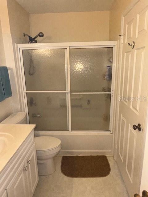 full bathroom featuring shower / bath combination with glass door, vanity, and toilet