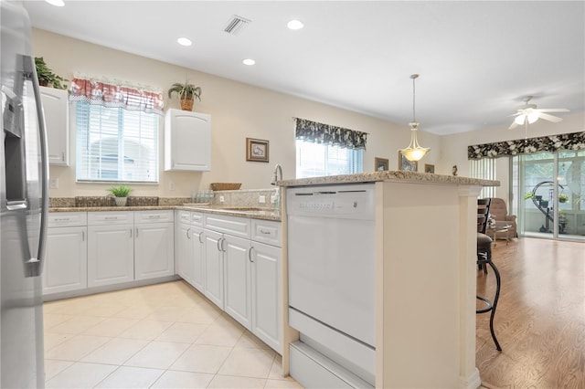 kitchen with ceiling fan, dishwasher, sink, light hardwood / wood-style floors, and white cabinets