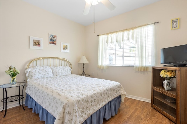 bedroom with multiple windows, wood-type flooring, and ceiling fan