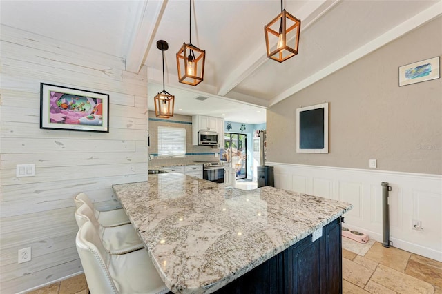 kitchen with white cabinets, stainless steel appliances, lofted ceiling with beams, and decorative light fixtures