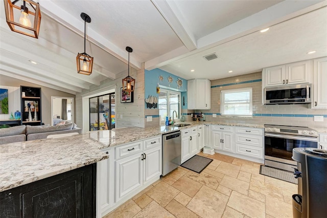 kitchen with decorative light fixtures, sink, stainless steel appliances, and white cabinetry