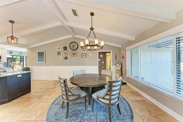 dining room featuring a notable chandelier and vaulted ceiling with beams