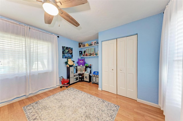 bedroom featuring ceiling fan, a closet, and light hardwood / wood-style flooring