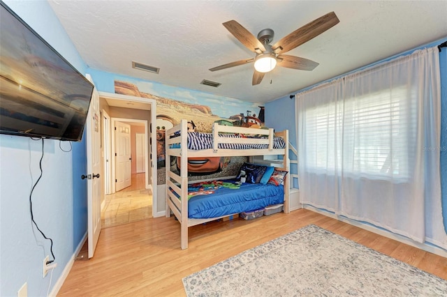 bedroom featuring a textured ceiling, light hardwood / wood-style flooring, and ceiling fan