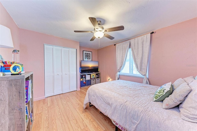 bedroom with ceiling fan, light hardwood / wood-style floors, and a closet