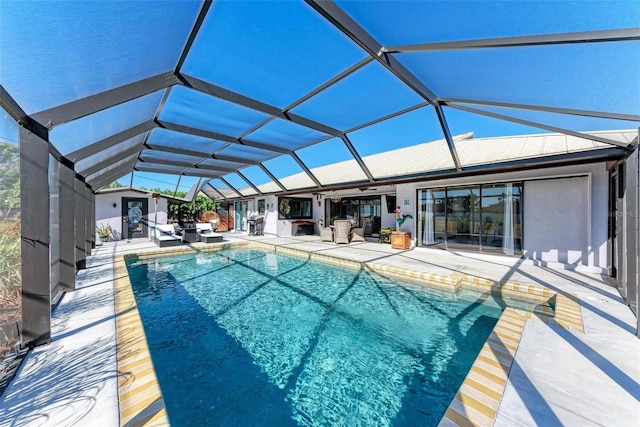 view of pool featuring glass enclosure, ceiling fan, and a patio area