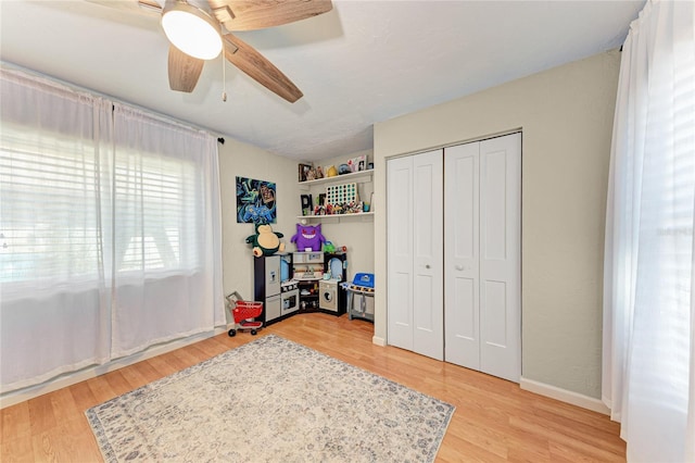 bedroom featuring ceiling fan, light wood-type flooring, and a closet