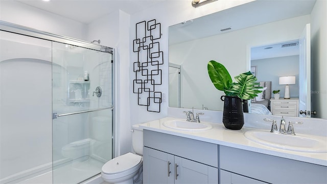 bathroom with vanity, toilet, and a shower with door