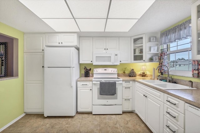 kitchen with white cabinetry, sink, light tile patterned flooring, and white appliances