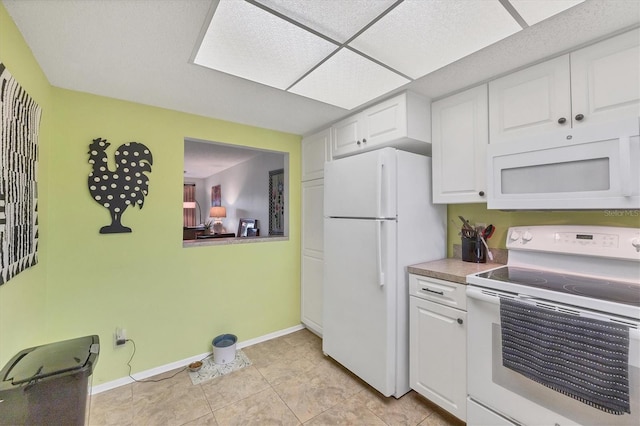 kitchen featuring white cabinetry, white appliances, and light tile patterned floors