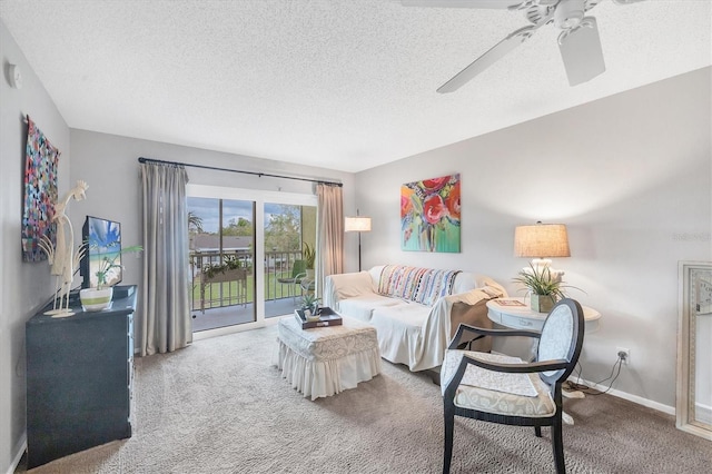 carpeted living room with ceiling fan and a textured ceiling