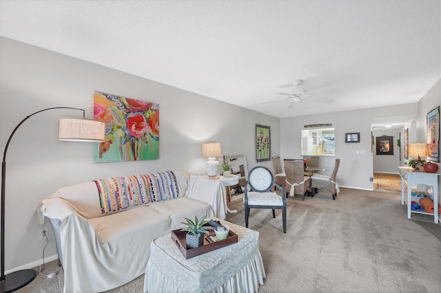 carpeted living room with ceiling fan and a textured ceiling