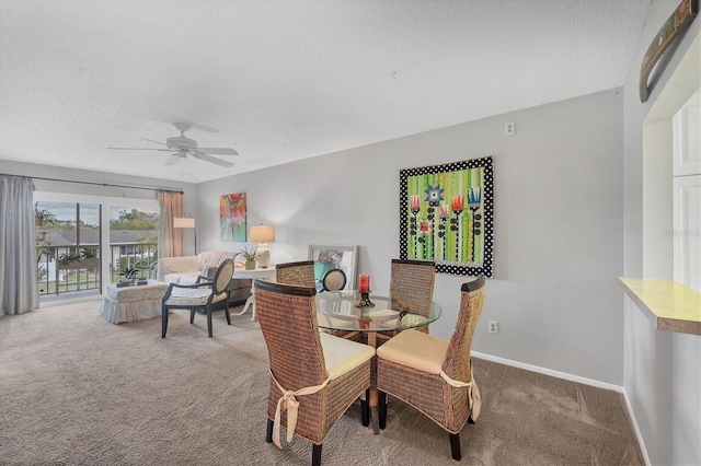 carpeted dining area with a textured ceiling and ceiling fan